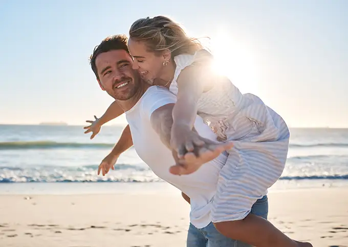Coppia felice che passeggia sulla spiaggia